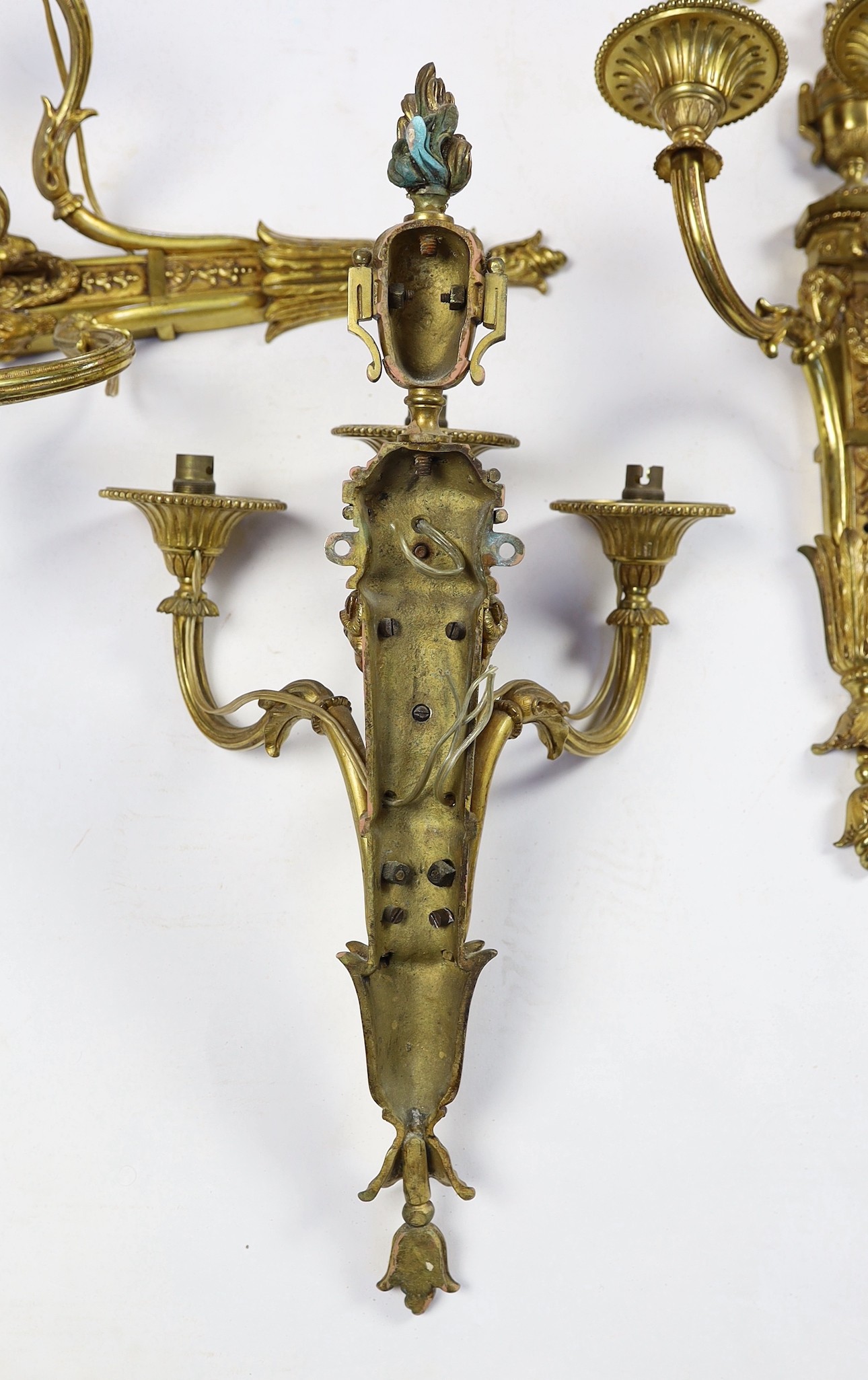 A set of eight cast gilt brass three branch wall sconces Height 23cm Width 22cm